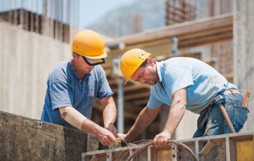 Construction workers collaborating in the installation of cement formwork frames